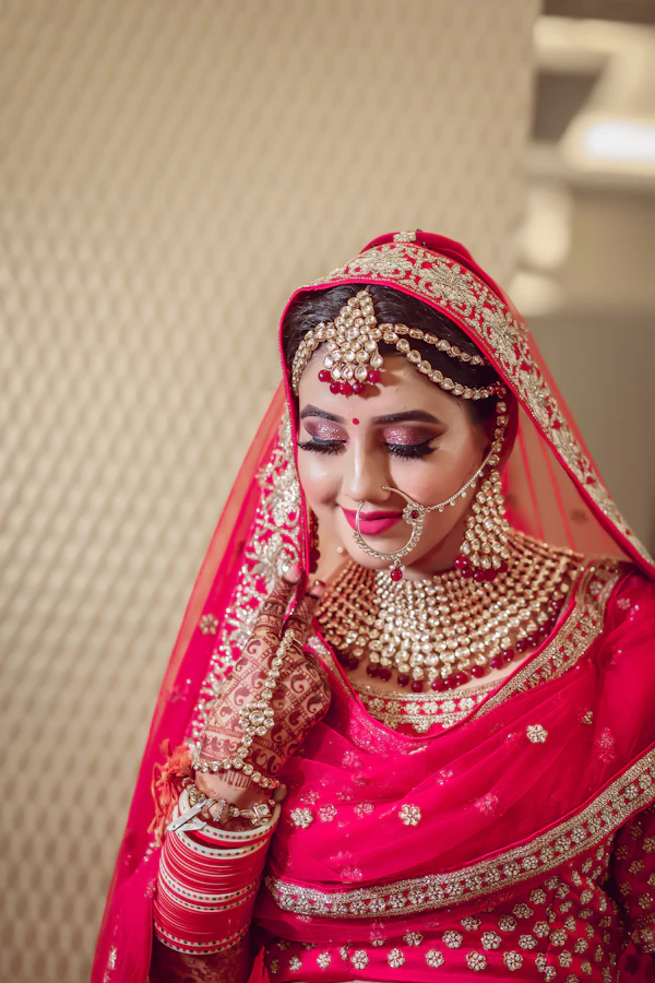 Bride in traditional red bridal wear and gold jewelry