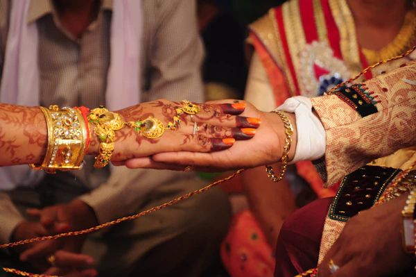 Bride and groom's hands with henna and gold bangles