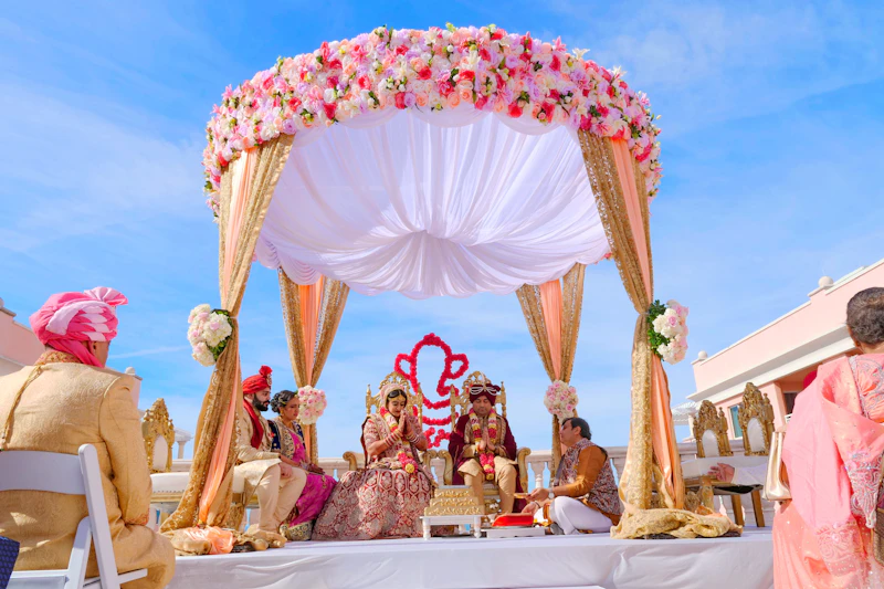 Traditional Indian wedding ceremony under a flower-decked mandap
